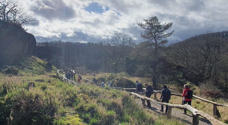 Wanderer auf Weg unterhalb Felsen