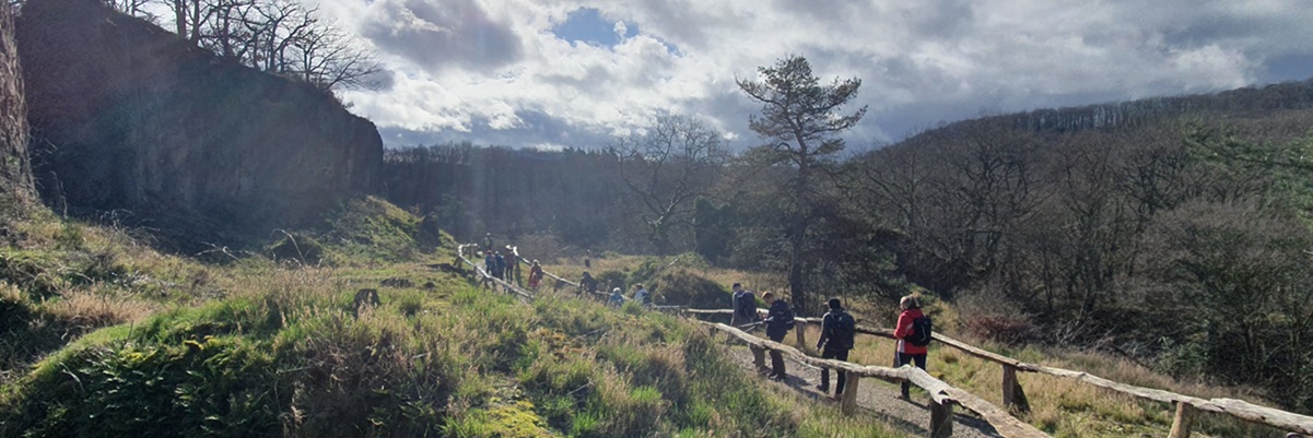 Wanderer auf Weg unterhalb Felsen